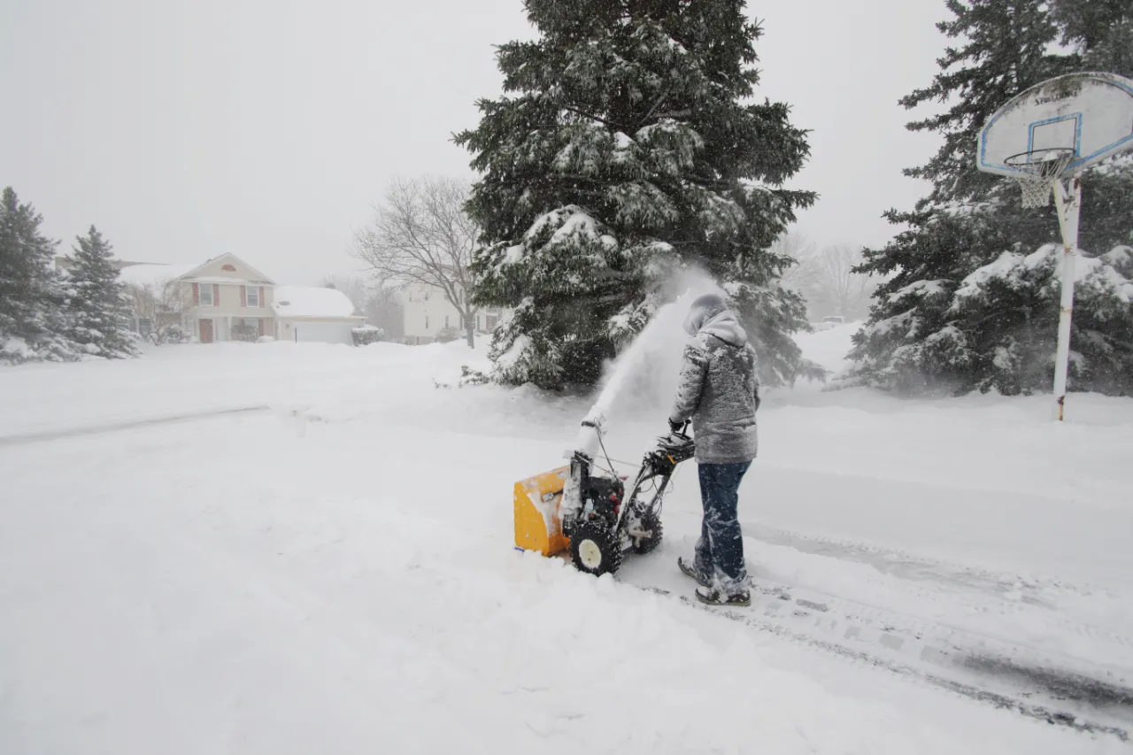 Clearing snowy driveway with snowblower