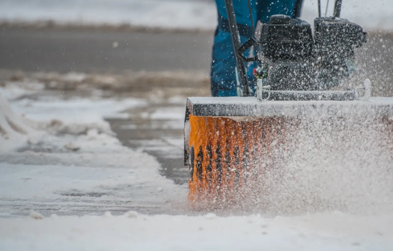 Snow removal machine clearing sidewalk